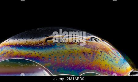 Soap bubble close up on black background. Stock Photo