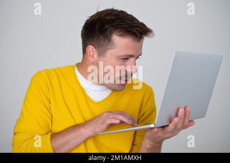 Thoughtful focused clever interested freelancer holding laptop with hands Stock Photo