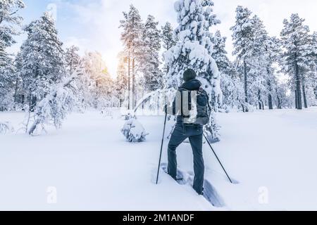Snowshoe hiker walking in the snow. Outdoor winter sport activity and healthy lifestyle concept. Stock Photo