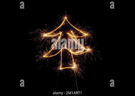 Christmas tree made by sparkler on a black background. Stock Photo