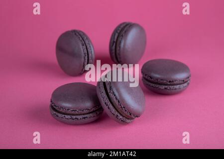 Closeup of brown macaroon cakes on red background Stock Photo