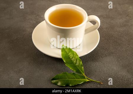 Tea leaves with a cup of green tea,on black background Stock Photo
