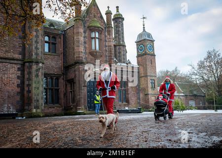 Walton Hall and Gardens, Warrington, Cheshire, England - Sunday 11 December 2022 - Warrington Disability Partnership held its second 3K Santa Dash around Walton Gardens on a slippy, snow covered circuit. Over 100 Santas took part raising money for the charity Credit: John Hopkins/Alamy Live News Stock Photo