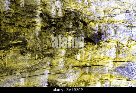 Weathered rock texture with yellow abstract reflections. Stone surface with yellow colored shapes. Stock Photo