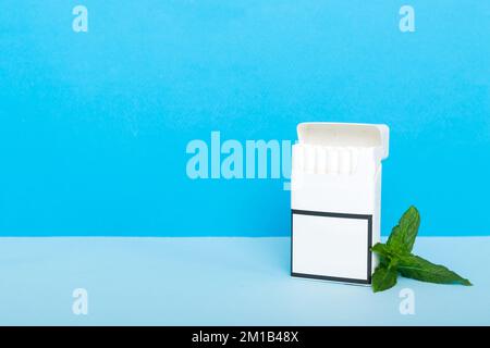 Pack of menthol cigarettes and fresh mint on colored table, Menthol cigarettes top view flat lay. Stock Photo