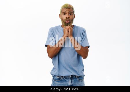 Man looks concerned, express compassion and worry, staring touched at camera, standing over white background Stock Photo