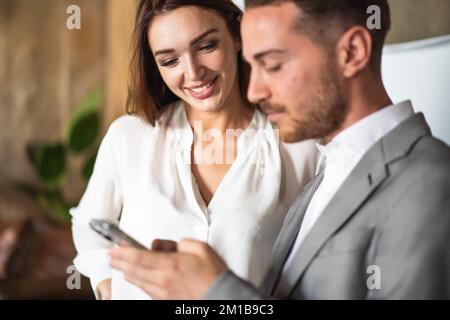 Young business executive man and his secretary standing in office discussing about new social and communication strategy Stock Photo