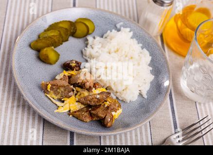 Fried omelette with rabbit liver, boiled rice and pickled cucumber Stock Photo