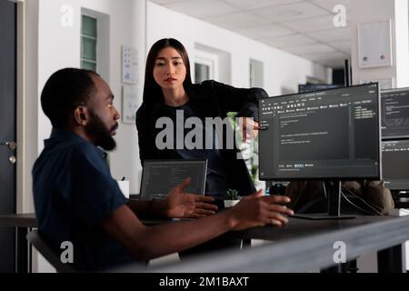 Diverse web developers working on software development with source code, looking at computer. System engineer writing ai algorithm in big data office, online cloud computing. Programming concept Stock Photo