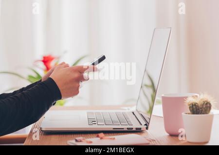 Woman at her workspace sending a message with her mobile phone. Concept of an enterprising woman. Use of technological media Stock Photo