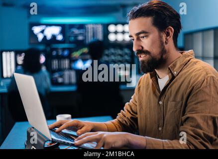 Young stock trader businessman working on laptop in dark office Stock Photo