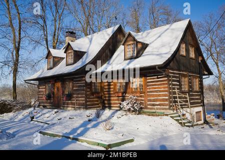 Old 1800s two story Canadiana cottage style log home in winter. Stock Photo