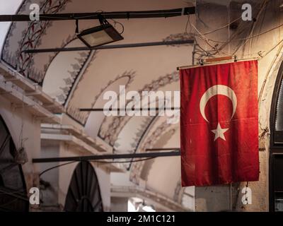 Picture of a turkish flags in the alleys of the Istanbul Grand Bazaar. Also known as Kapalicarsi, it is one of the largest and oldest covered markets Stock Photo