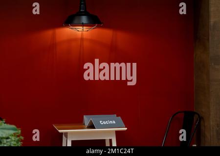 wooden table with a single chair, on a red background, quality light lamp, mexico Stock Photo