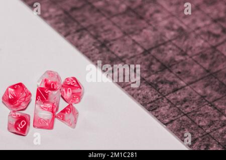 A set of polyhedral dice used for role playing games such as Dungeons Dragons. A fresh classic for 2023 in Viva Magenta. Color concept of the year. Stock Photo