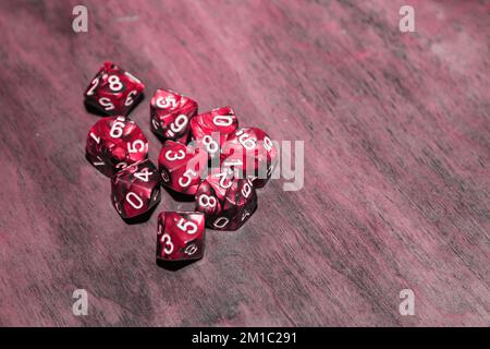 A set of polyhedral dice used for role playing games such as Dungeons Dragons. A fresh classic for 2023 in Viva Magenta. Color concept of the year. Stock Photo