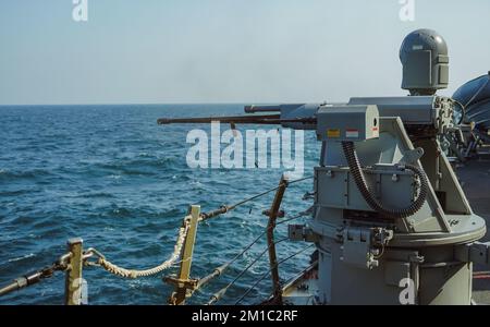 221203-N-EB711-1004 ARABIAN GULF (Dec. 3, 2022) An MK38 25mm machine gun is fired aboard guided-missile destroyer USS The Sullivans (DDG 68) in the Arabian Gulf, Dec. 3. The Sullivans is deployed to the U.S. 5th Fleet area of operations to help ensure maritime security and stability in the Middle East region. (U.S. Navy photo by Sonar Technician (Surface) 1st Class Kevin Frus) Stock Photo