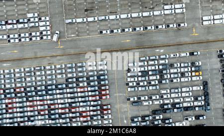 Aerial view of new cars stock at factory parking lot. Above view cars parked in a row. Automotive industry. Logistics business. Import or export new Stock Photo
