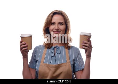 takeaway and people concept - young woman in apron holds two takeaway paper cup isolated over white background Stock Photo
