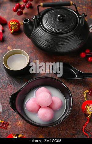 Bowl of tangyuan, cup, teapot and Chinese decor on light background ...
