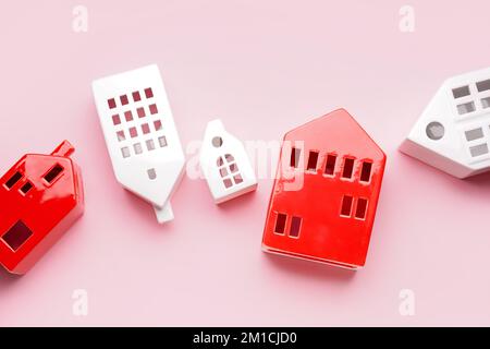 House shaped candle holders on pink background Stock Photo