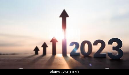 High rising arrow and bright rising sun 2023 new year sunrise and stock finance economy industry growth investment target concept Stock Photo