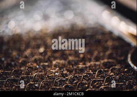 Selective focus macro of a dirty kitchen range hood filter clogged with grease. Stock Photo