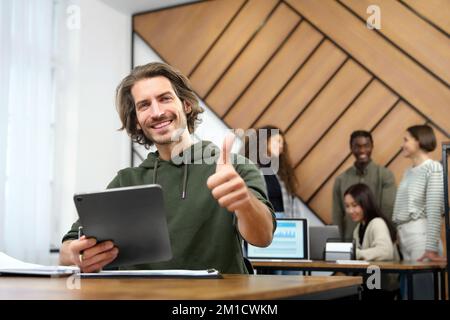 smiling young entrepreneur giving a thumbs up. Stock Photo