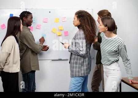 business team discussing sticky notes on the wall. Stock Photo