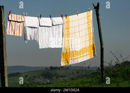 Washing on clothes line in front of tuscanian landscape, Italy Stock Photo