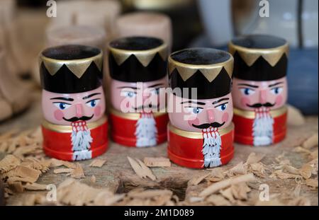 PRODUCTION - 08 December 2022, Saxony, Seiffen: Small nutcrackers as crew for a new type of smoke rocket stand in the workshop of wooden toy maker Markus Füchtner in Seiffen. Scientists from the Fraunhofer Institute for Machine Tools and Forming Technology spent six months working with the team led by wooden toy maker Markus Füchtner. Now, during Advent, they are raising the curtain on the prototype of their smoking rocket. The warmth of an incense candle opens the tip of the rocket as if by magic and a mini nutcracker peeps out. The secret behind it is a spring that expands when exposed to he Stock Photo