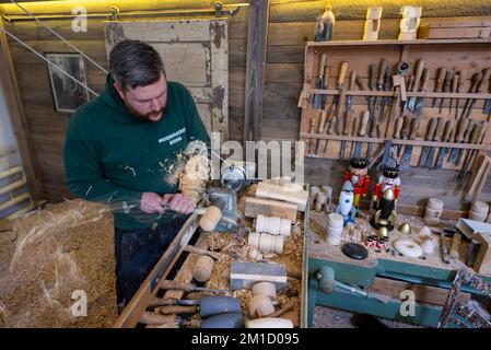 PRODUCTION - 08 December 2022, Saxony, Seiffen: Wooden toy maker Markus Füchtner turns in his workshop in Seiffen. Scientists at the Fraunhofer Institute for Machine Tools and Forming Technology spent six months working with the team led by wooden toy maker Markus Füchtner. Now, during Advent, they are raising the curtain on the prototype of their smoking rocket. The warmth of an incense candle opens the tip of the rocket as if by magic and a mini nutcracker peeps out. The secret behind it is a spring that expands when exposed to heat. Experts talk about shape-memory alloys. This Christmas, ho Stock Photo