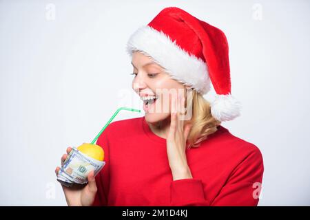 Girl santa hat drink juice lemon wrapped in banknote. Totally natural lemon juice. Fresh lemonade drink with straw. Symbol of wealth and richness Stock Photo