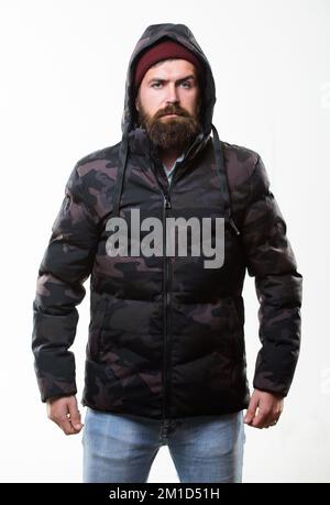 Comfortable winter outfit. Winter stylish menswear. Man bearded stand warm camouflage pattern jacket parka isolated on white background. Hipster Stock Photo