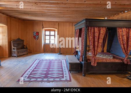 Lord’s bedroom with canopy bed in medieval Predjama Castle interior in Slovenia. Stock Photo