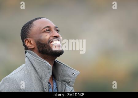 Happy black man laughing looking up in winter outdoors Stock Photo