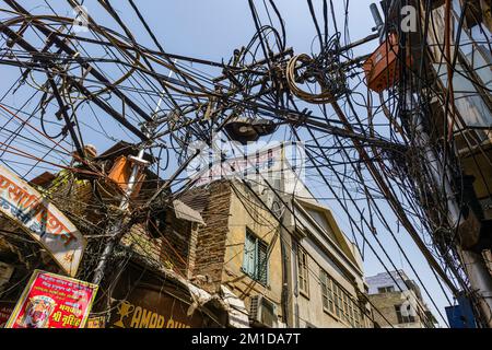 A chaotic arrangement of electricity cables in a little sidestreet of Khari Baoli Road in Old Delhi Stock Photo