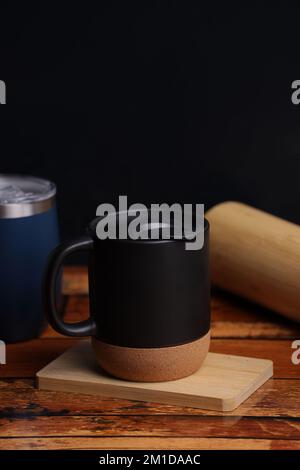 ceramic mug mock up image, seramic mug with woodern bottom on the wood table Stock Photo