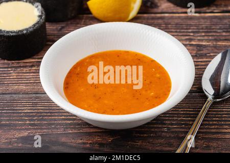 Lentil soup in white porcelain bowl on wooden table Stock Photo