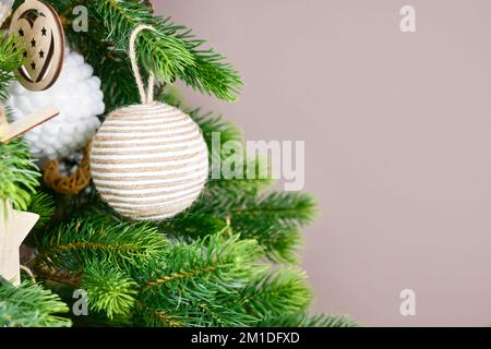 Christmas tree branches with natural ornament bauble made from beige jute rope with copy space Stock Photo
