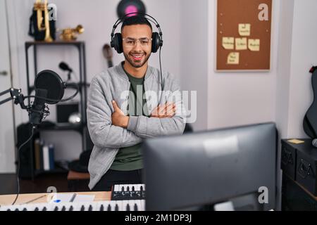 African american man musician sitting with arms crossed gesture at music studio Stock Photo
