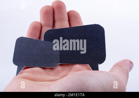 Hand holding dialogue boxes on a white background Stock Photo