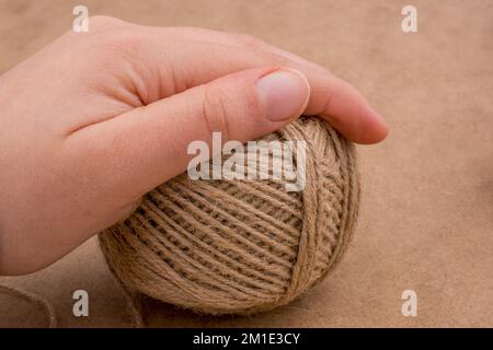 Spools of thread in hand isolated on a brown background Stock Photo