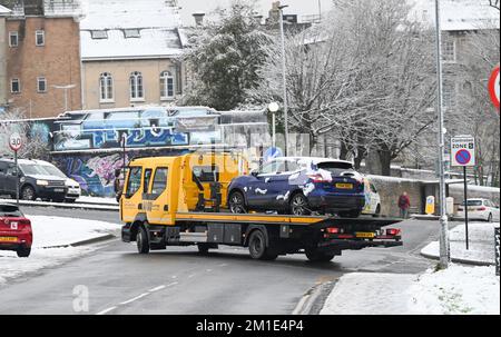 Brighton UK 12th December 2022 - A broken down car is rescued during the snow in Brighton this morning as the freezing weather is forecast to last for the next few days throughout Britain . : Credit Simon Dack / Alamy Live News Stock Photo