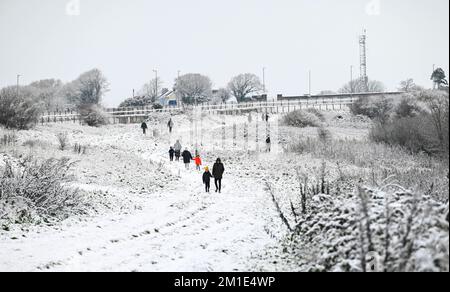 Brighton UK 12th December 2022 - Walkers out in the snow near Brighton Racecourse this morning as the freezing weather is forecast to last for the next few days throughout Britain . : Credit Simon Dack / Alamy Live News Stock Photo