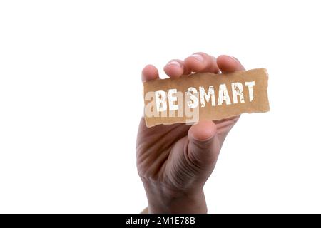 Hand holding torn notepaper with be smart word Stock Photo