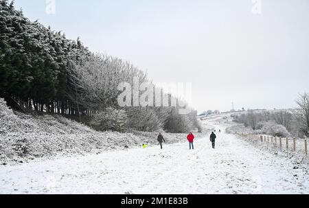 Brighton UK 12th December 2022 - Walkers out in the snow near Brighton Racecourse this morning as the freezing weather is forecast to last for the next few days throughout Britain . : Credit Simon Dack / Alamy Live News Stock Photo