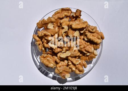 A plate full of ripe walnuts on the white background Stock Photo