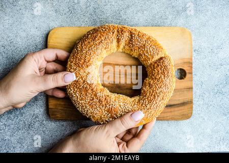 Overhead view of a woman holding a Greek sesame bread ring (koulouria)