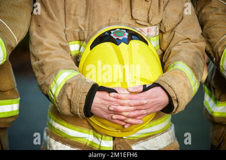 Fireman showing respect holding his helmet Stock Photo